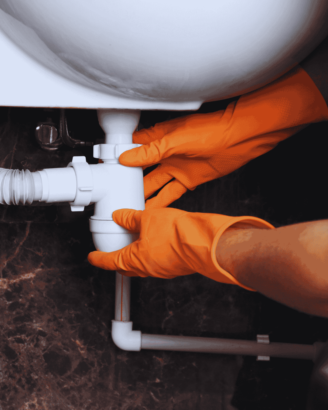 Licensed plumber tightening a pipe fitting during a Boynton Beach service call